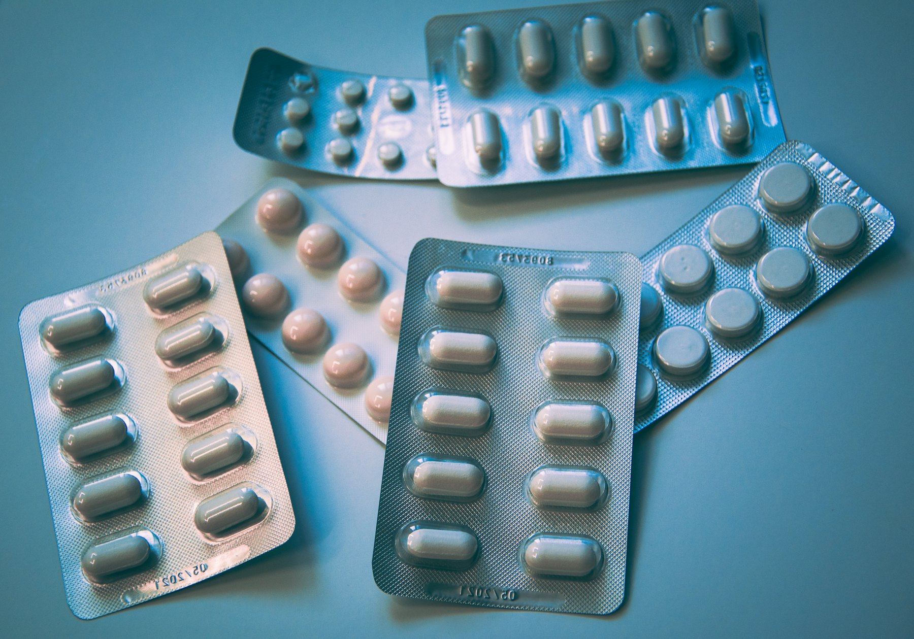 Blister packs of tablets on a pale blue surface